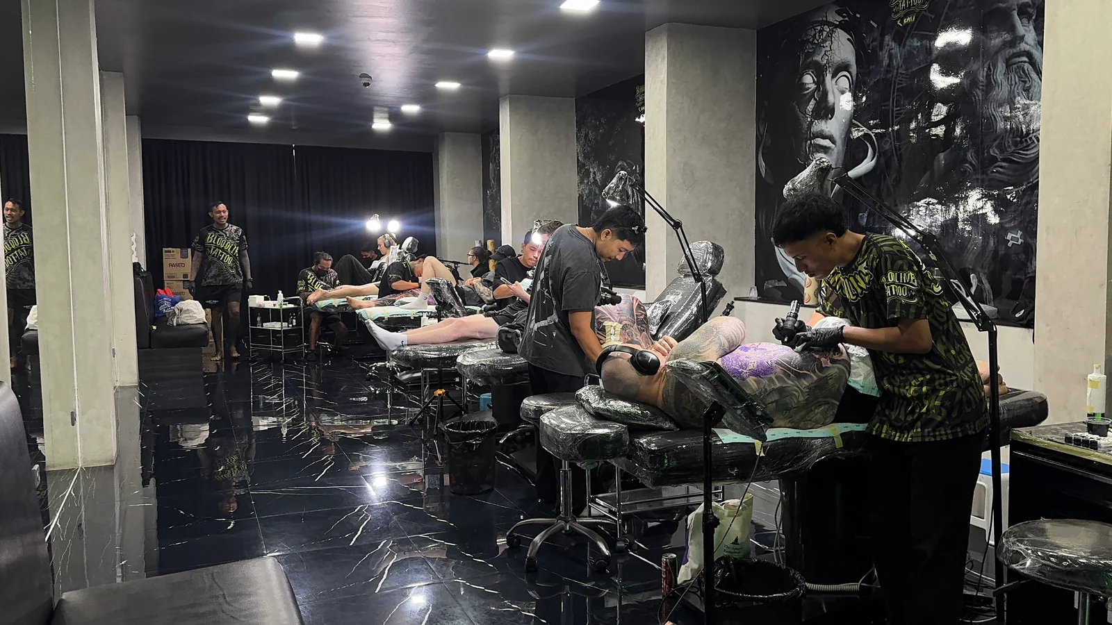 Bali tattoo artist at work in professional studio with multiple stations